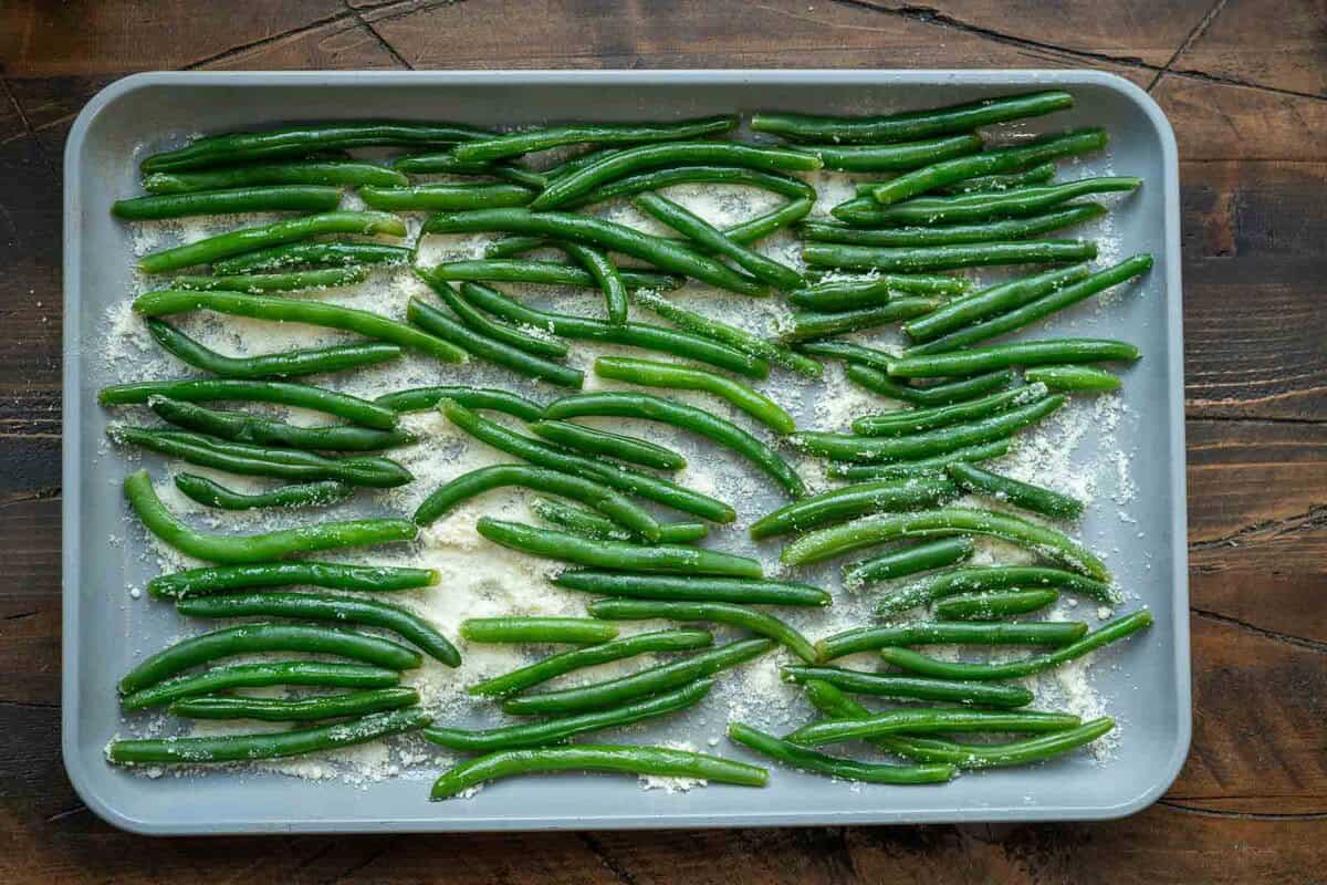 green beans and parmesan spread on a baking sheet