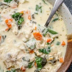 overhead image of chicken florentine soup in a brown and white bowl with a spoon