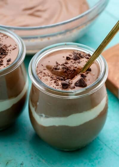 two jars of cottage cheese chocolate mousse on a table with a spoon