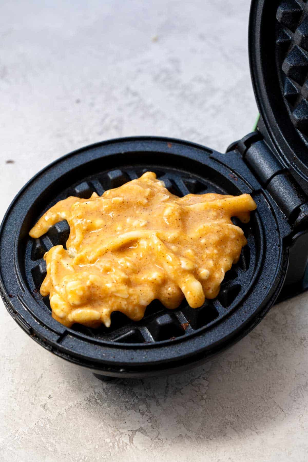 pumpkin chaffle batter laid onto waffle maker
