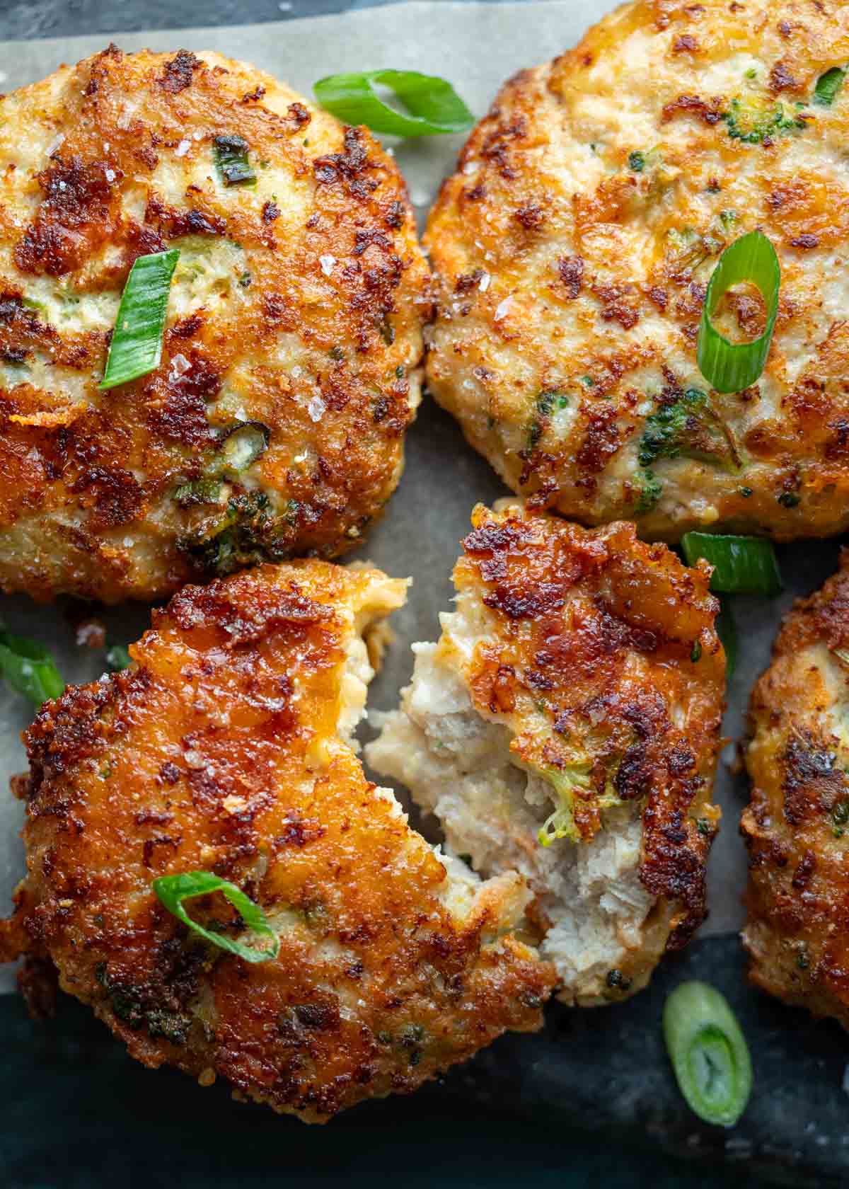 a broccoli cheddar chicken fritter broken in two showing the tender filling