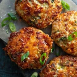 overhead image of four broccoli cheddar chicken fritters on gray cutting board