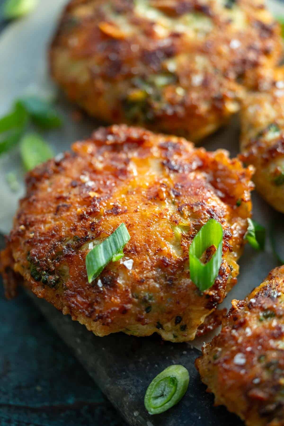 close up image of one cooked and garnished chicken fritter
