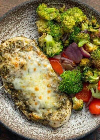 close up, overhead image of chicken pesto and vegetables on a white plate