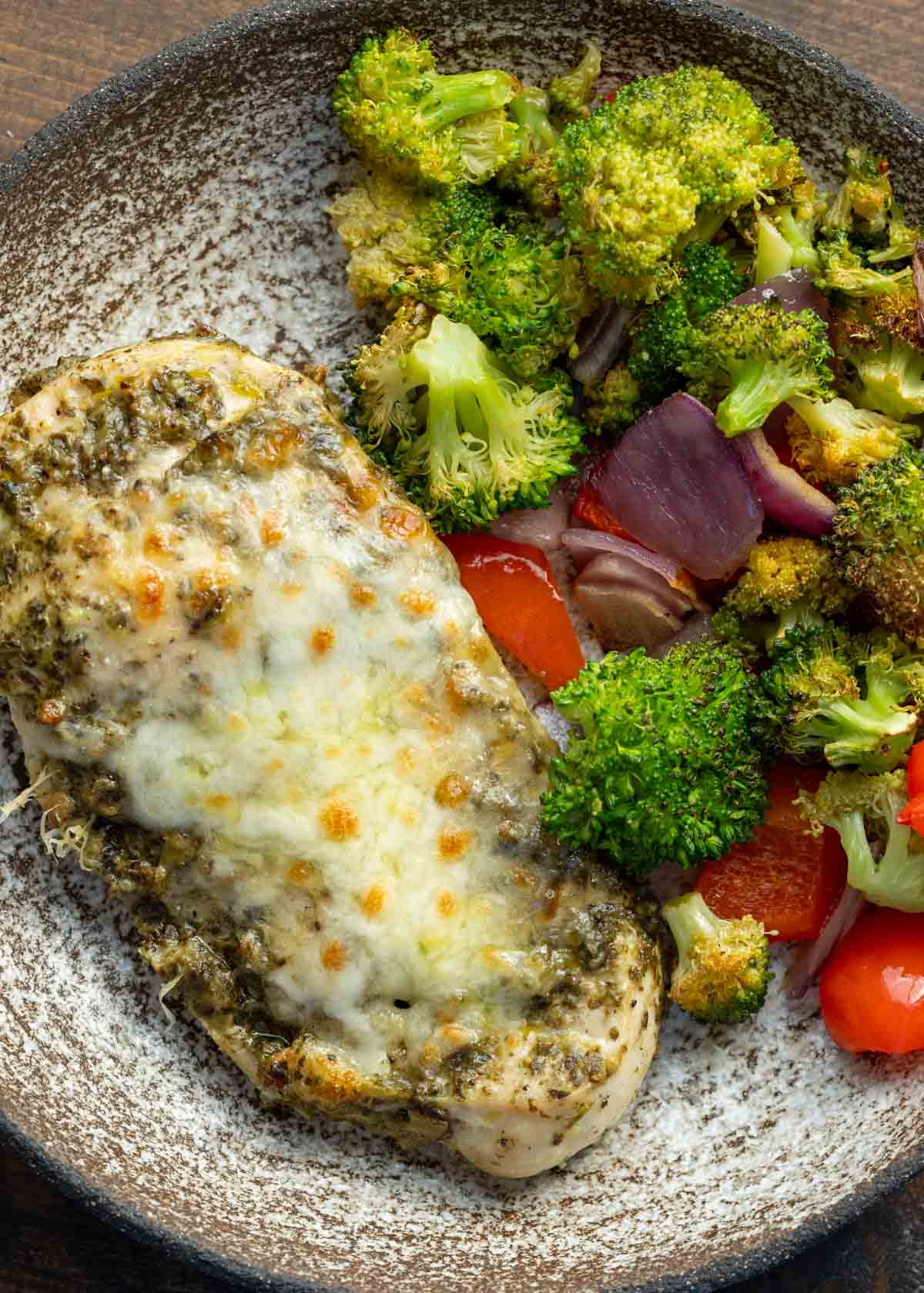 close up, overhead image of chicken pesto and vegetables on a white plate
