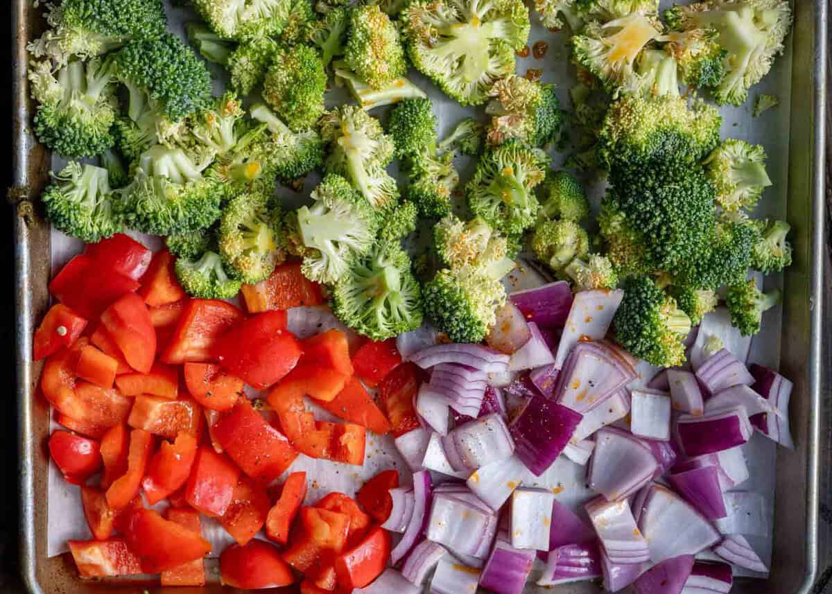 chopped bell pepper, red onion, and broccoli in a sheet pan