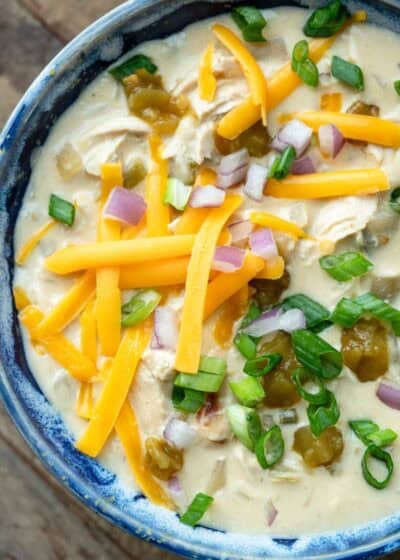 close, overhead image of chicken soup with green chiles in a blue bowl