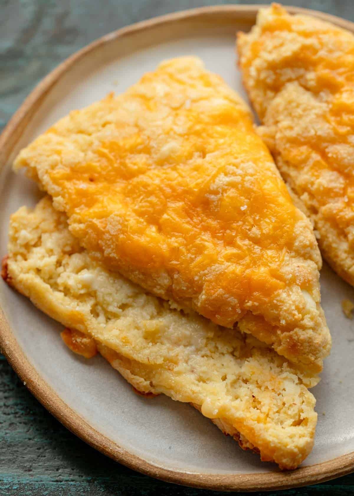 close overhead image of a sliced cheese scone on a white plate