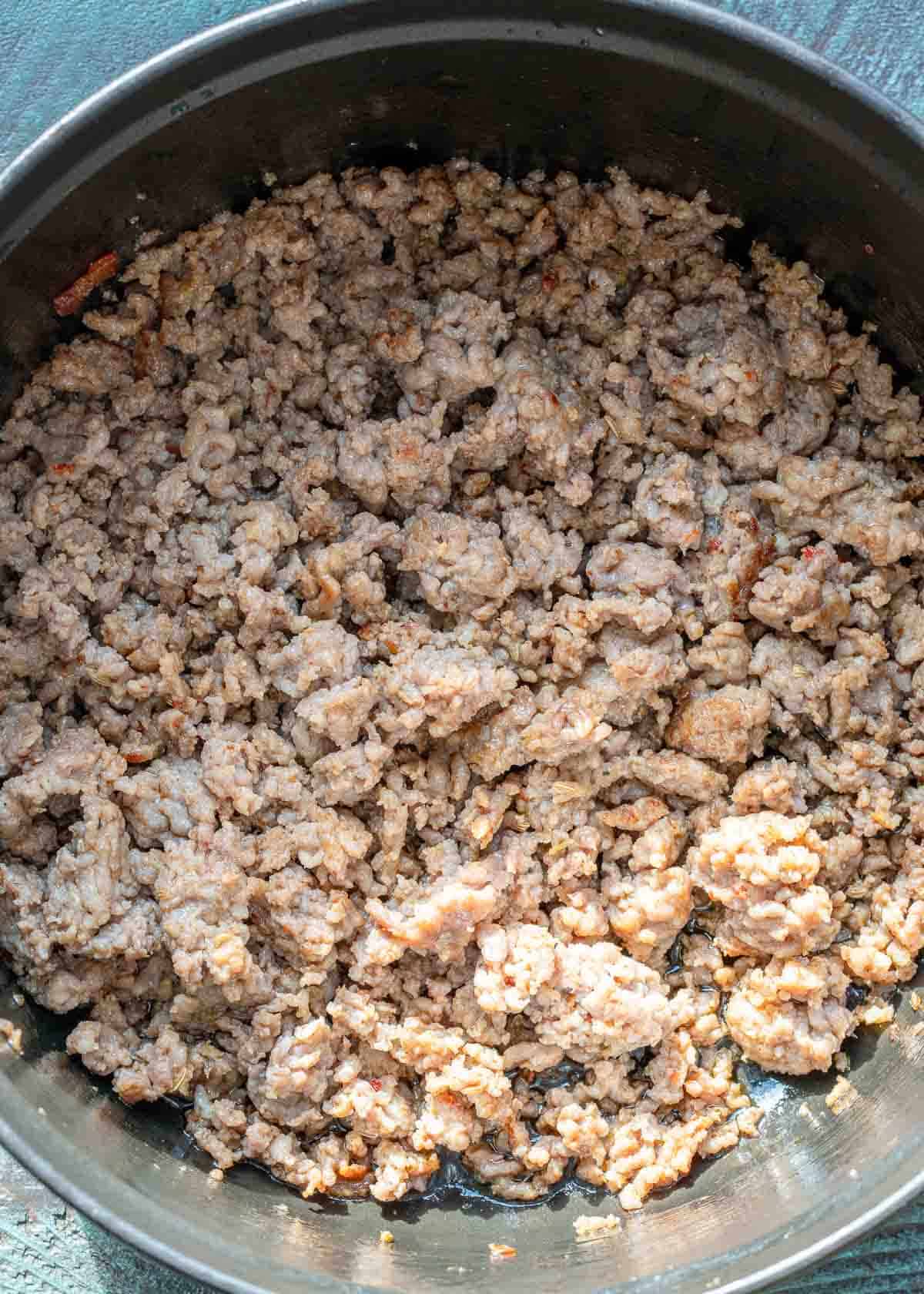 overhead image of Italian sausage cooking in a dutch oven