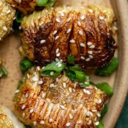 close up, overhead image of two pork dumplings on a brown plate