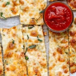 overhead image of zucchini breadsticks and small bowl of marinara sauce