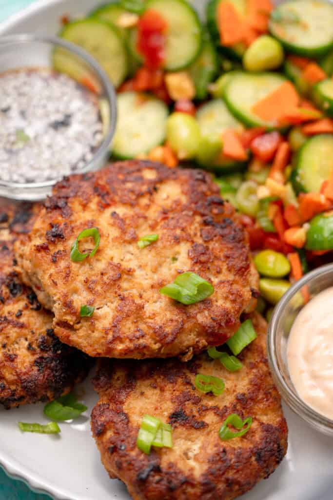 overhead shot of asian chicken fritters on a white plate