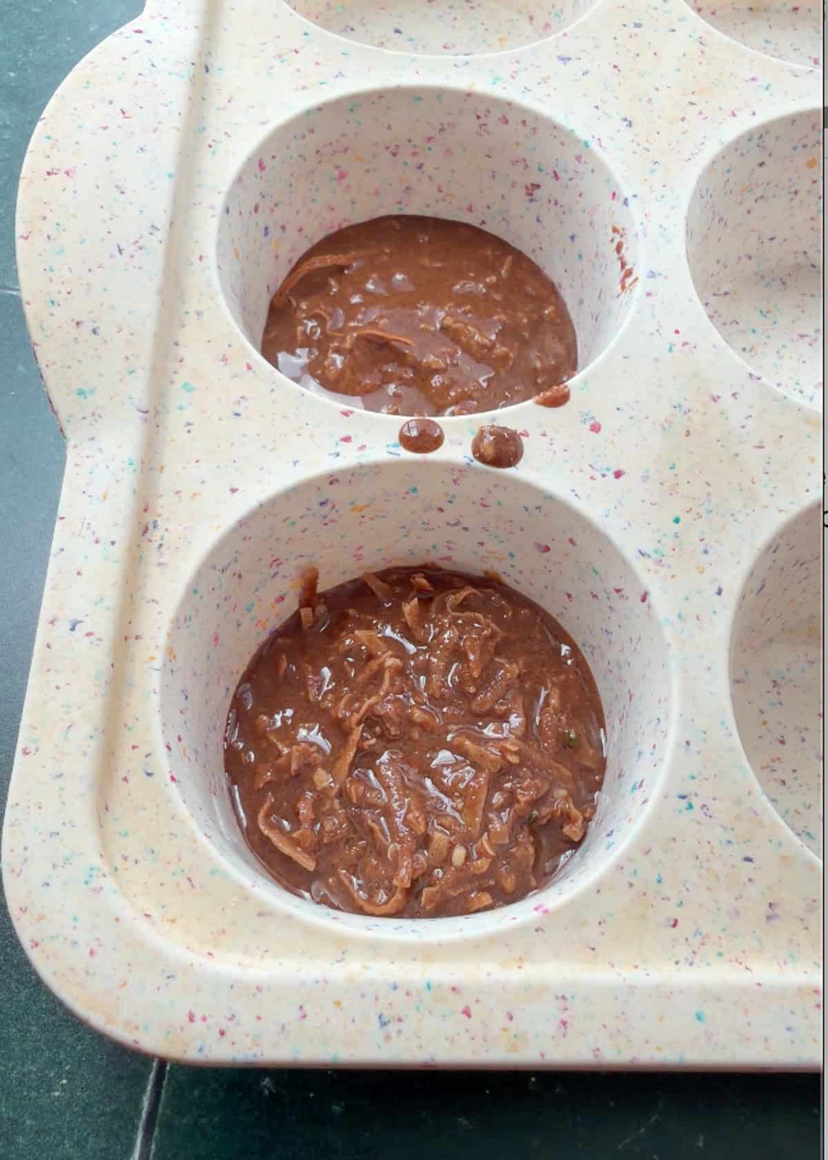 no bake almond butter cookie mixture being added to mini muffin tin