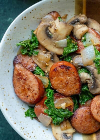 overhead image of andouille sausage and vegetables in a white and brown bowl
