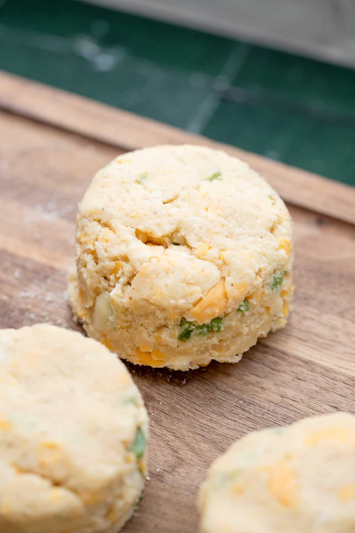jalapeno cheddar keto biscuit mix being rolled out on wooden cutting board