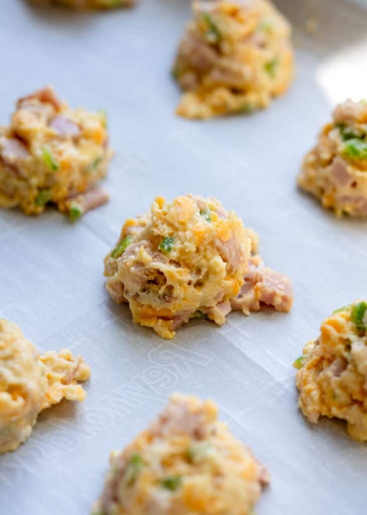 ham, cheddar, and jalapeno bites patted out on parchment paper