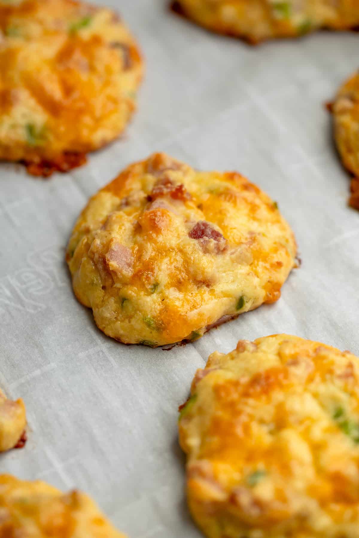 cooked ham, cheddar, and jalapeno bites on parchment paper